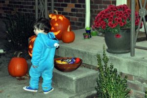 child getting candy from a bowl
