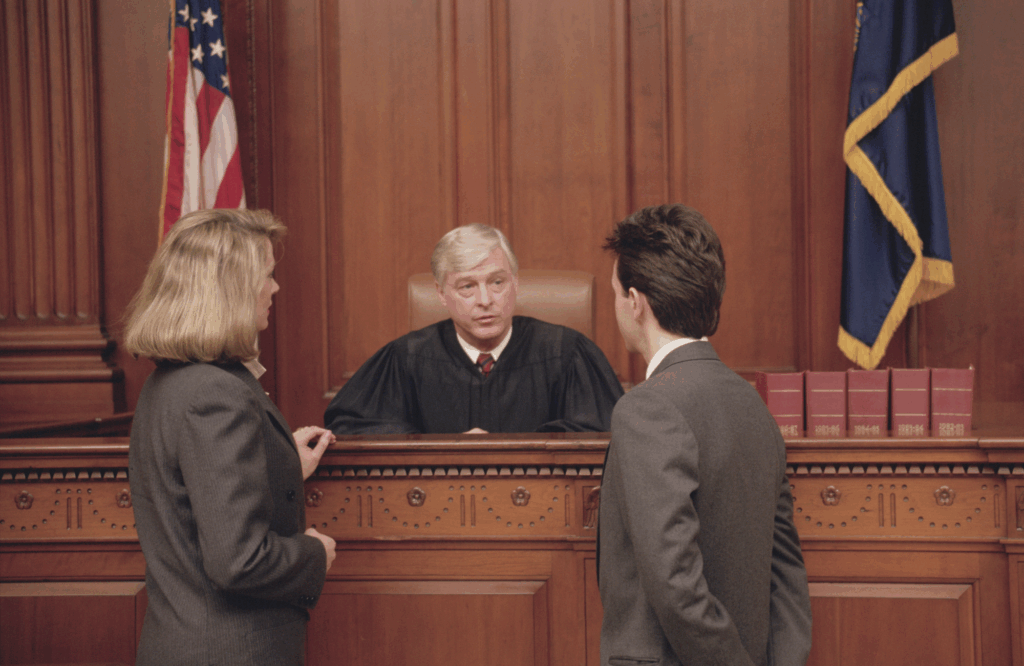 Judge in a courtroom addressing attorneys during a bail hearing, depicting the critical decision-making at stake under proposed constitutional changes to pretrial detention rules.