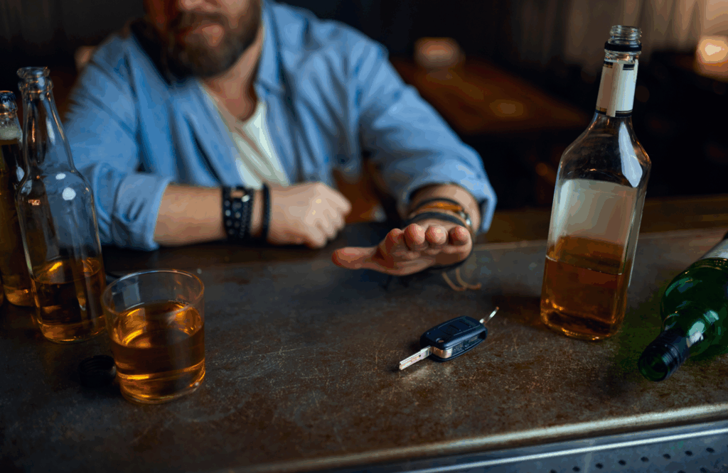 Man at a bar pushing away car keys surrounded by alcohol, reflecting Texas's proposed crackdown on DWI offenses and elevated legal consequences for first-time and repeat offenders.